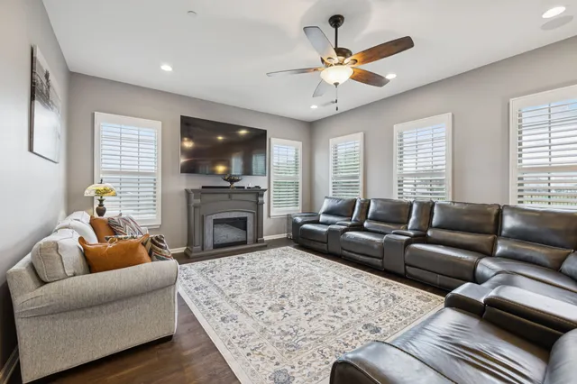 a living room with furniture a flat screen tv and a fireplace
