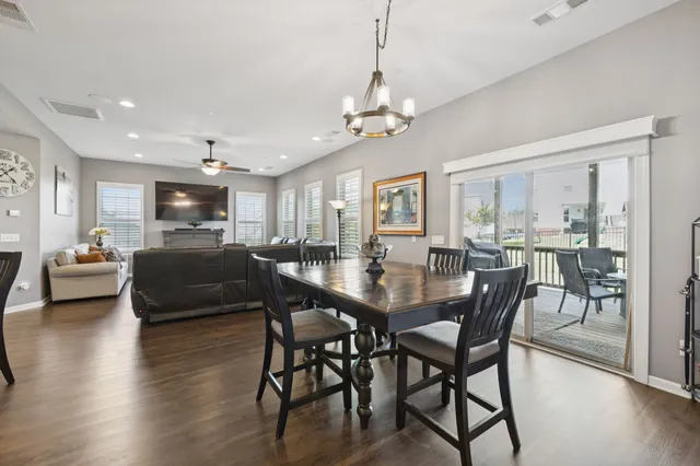 a view of a dining room and livingroom with furniture wooden floor a chandelier