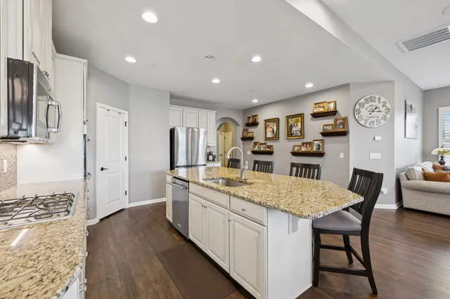 a kitchen with stainless steel appliances granite countertop a kitchen island a stove and a refrigerator