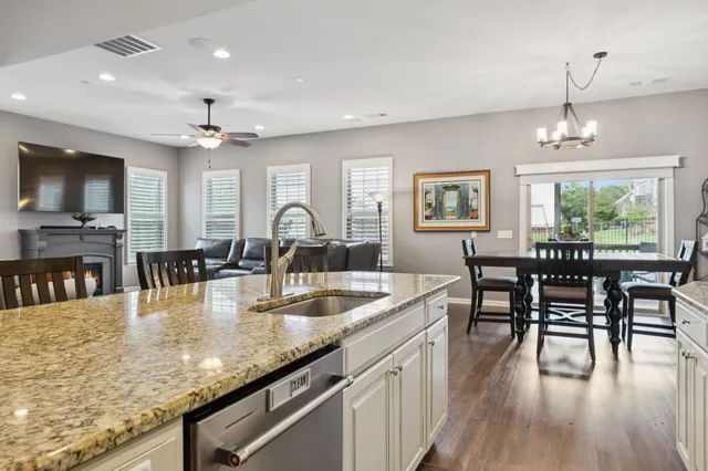 a view of a dining room and livingroom with furniture wooden floor a chandelier