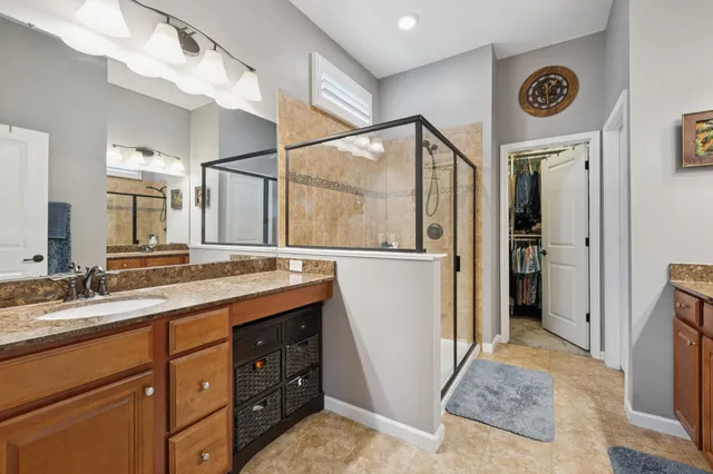 a spacious bathroom with a sink a mirror and a shower