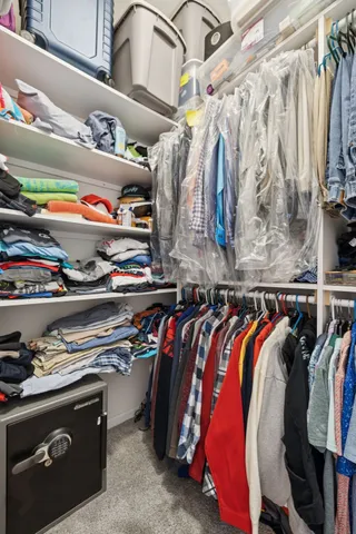 a view of walk in closet with clothes and shoes