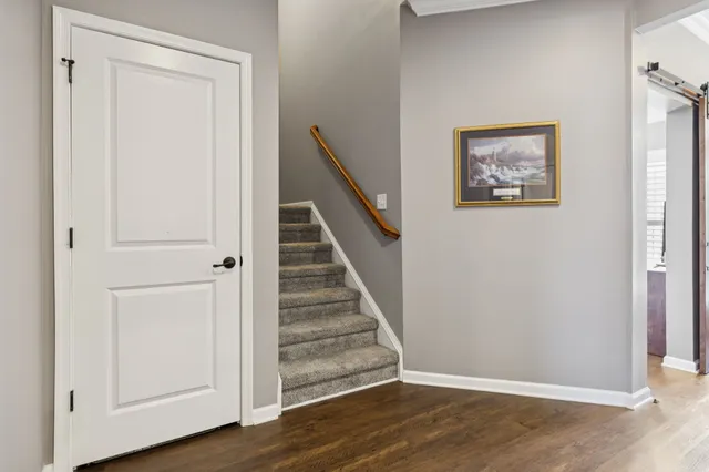 a view of a hallway with wooden floor and entryway