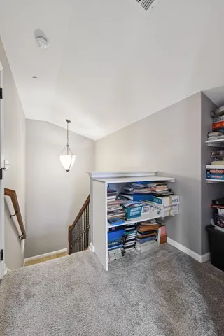 a spacious bedroom with a bed and a chandelier