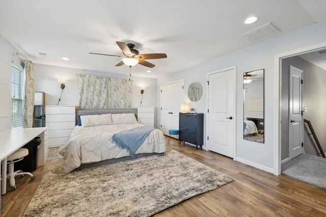 a spacious bedroom with a bed and a flat screen tv