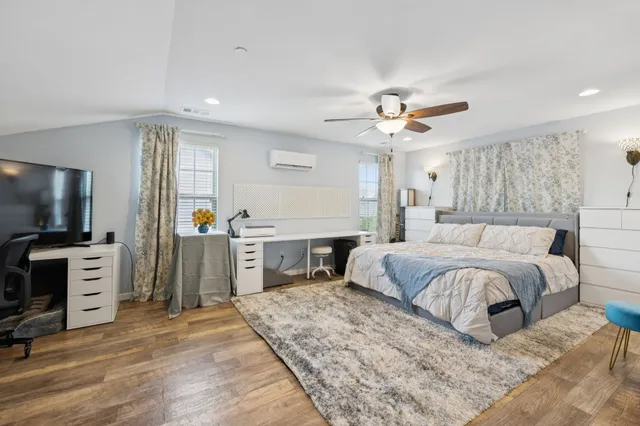 a bedroom with a bed a window and flat screen tv
