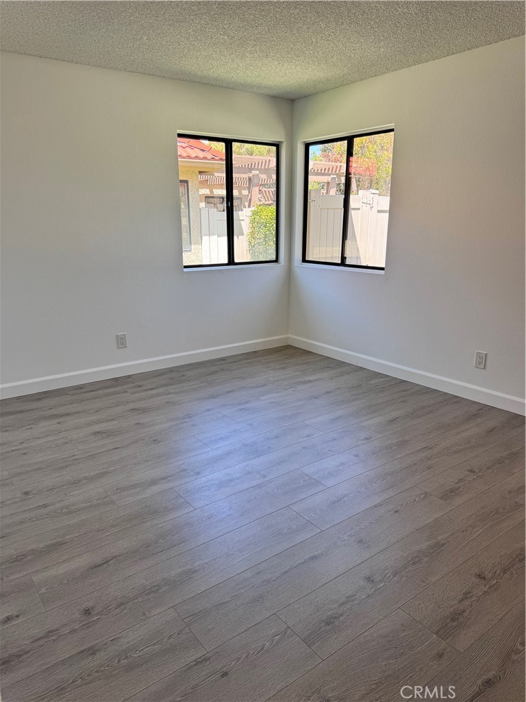 26226 Rainbow Glen Drive Newhall, CA 91321 - Photo 12 of 27 an empty room with wooden floor and windows