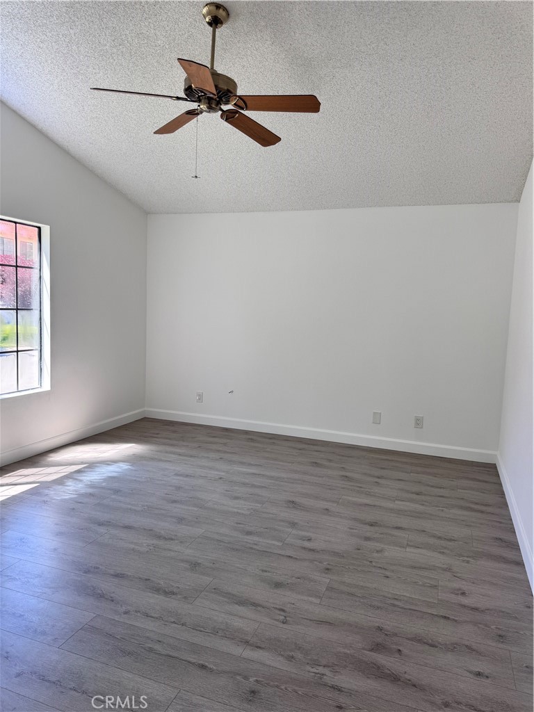 26226 Rainbow Glen Drive Newhall, CA 91321 - Photo 13 of 27 a view of a room with wooden floor a ceiling fan and windows