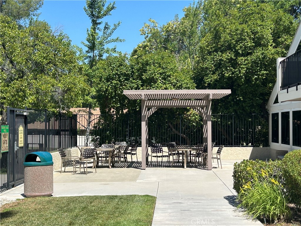 26226 Rainbow Glen Drive Newhall, CA 91321 - Photo 24 of 27 a view of a patio with a table and chairs and potted plants