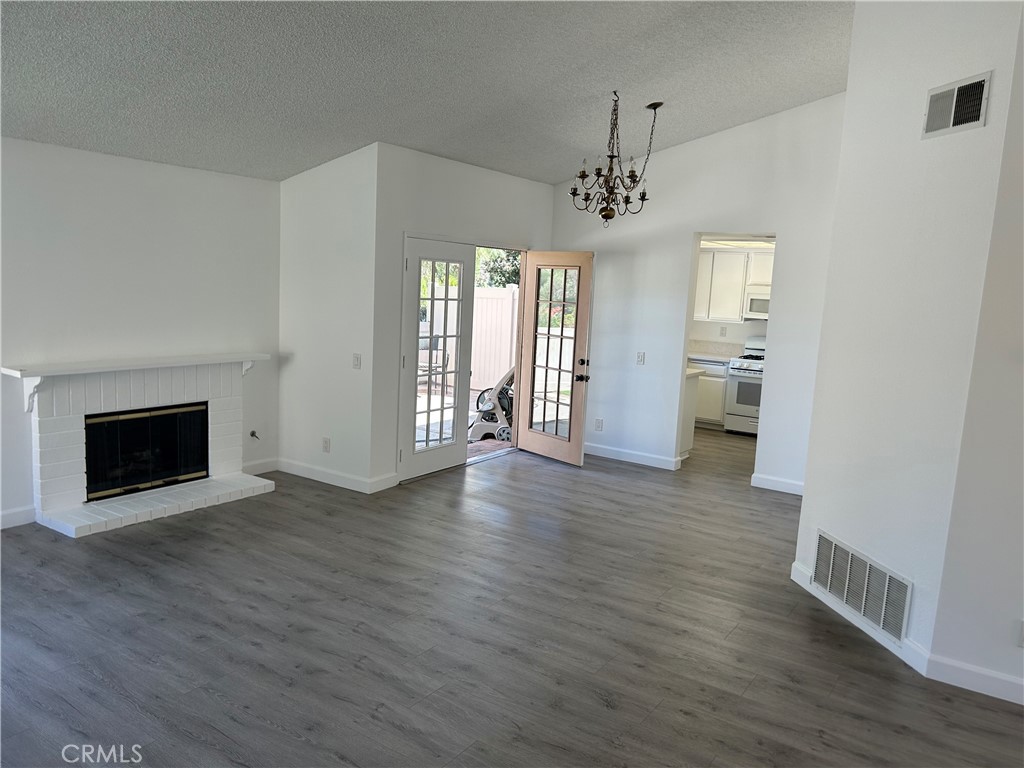 26226 Rainbow Glen Drive Newhall, CA 91321 - Photo 3 of 27 an empty room with wooden floor fireplace and windows