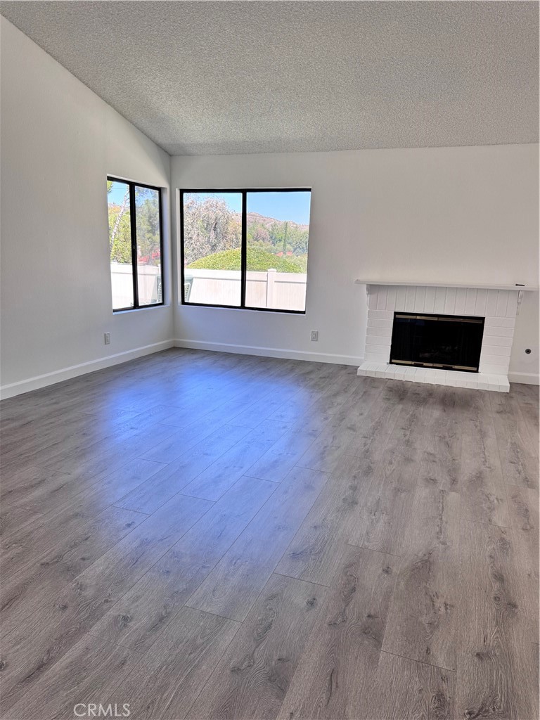 26226 Rainbow Glen Drive Newhall, CA 91321 - Photo 4 of 27 a view of an empty room with a window and wooden floor