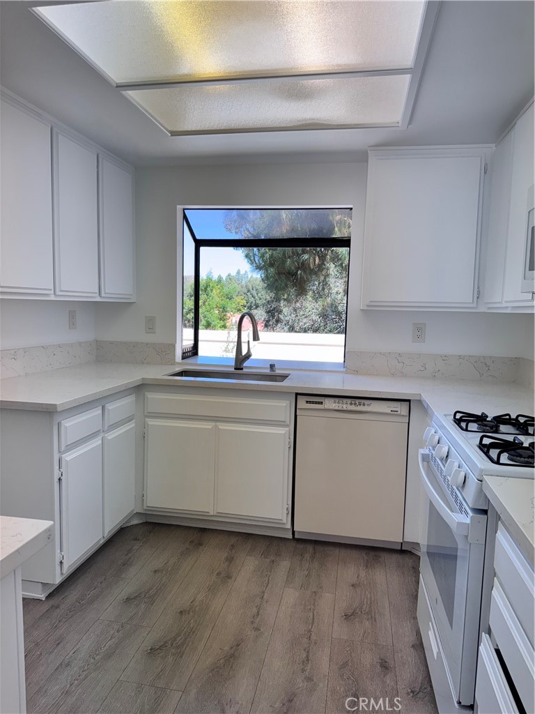 26226 Rainbow Glen Drive Newhall, CA 91321 - Photo 6 of 27 a kitchen with granite countertop white cabinets and a stove