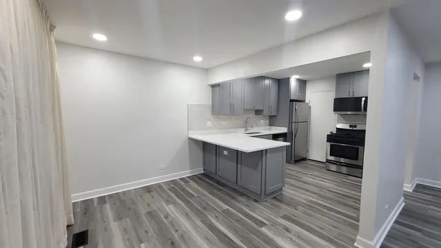 a kitchen with kitchen island a sink appliances and cabinets