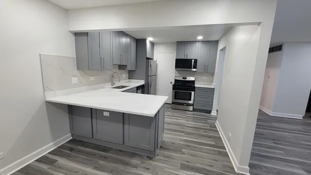 a kitchen with kitchen island a sink stainless steel appliances and cabinets