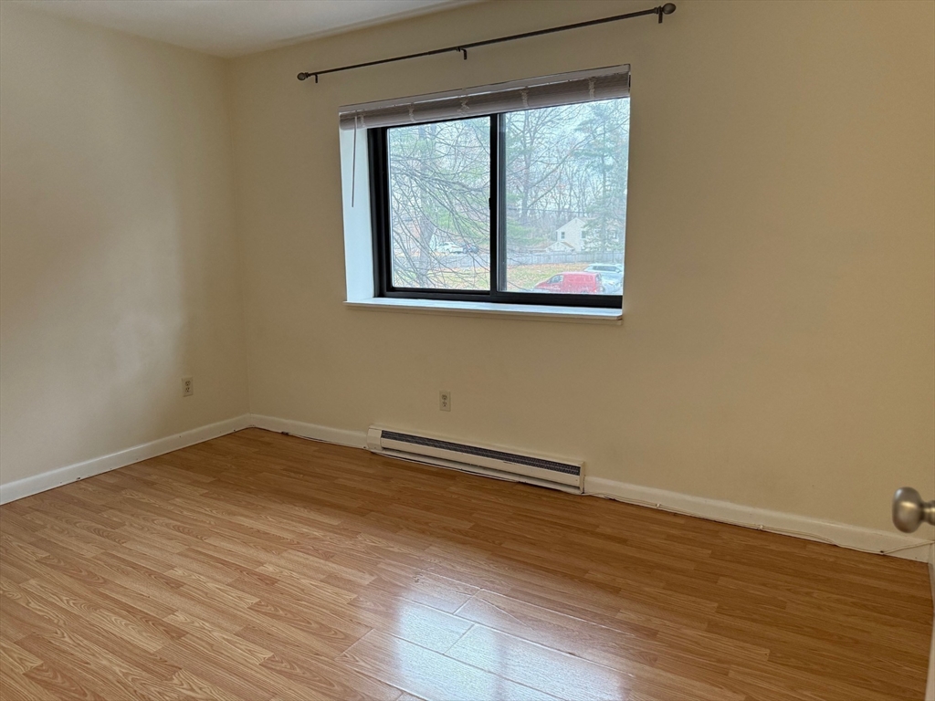 1325 Worcester Road, Unit D8 Framingham, MA 01701 - Photo 13 of 20 a view of an empty room with wooden floor and a window
