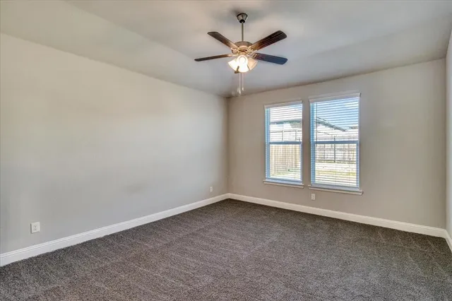 an empty room with a window and a fan