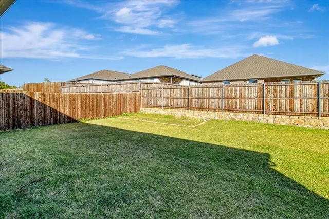 a view of a big house with a big yard and a large tree