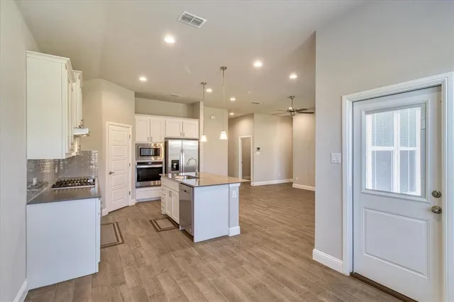 a view of kitchen with refrigerator and microwave