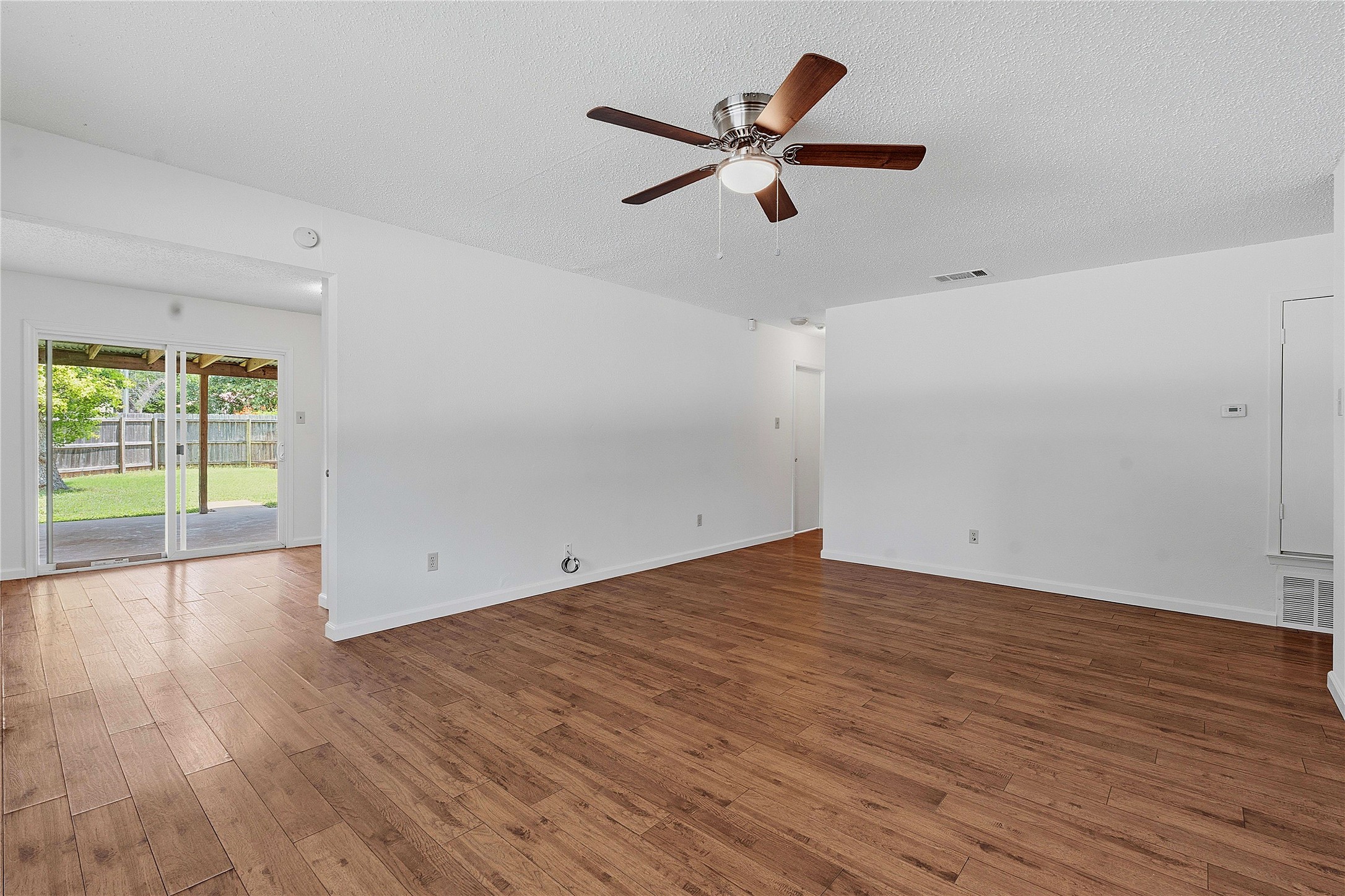 6205 Shadow Bend Austin, TX 78745 - Photo 15 of 31 Rich hardwood-style flooring extends through this airy living space with sliding glass doors opening to a fenced yard.