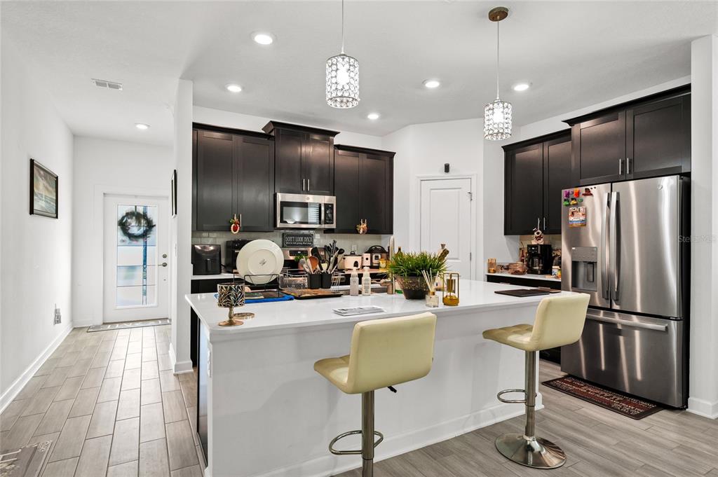 5656 Quiet Palm Loop St. Cloud, FL 34771 - Photo 13 of 36 a kitchen with sink refrigerator and cabinets