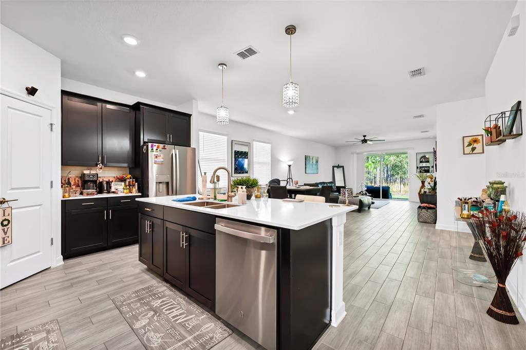 5656 Quiet Palm Loop St. Cloud, FL 34771 - Photo 15 of 36 a kitchen with stainless steel appliances granite countertop a sink a stove and refrigerator