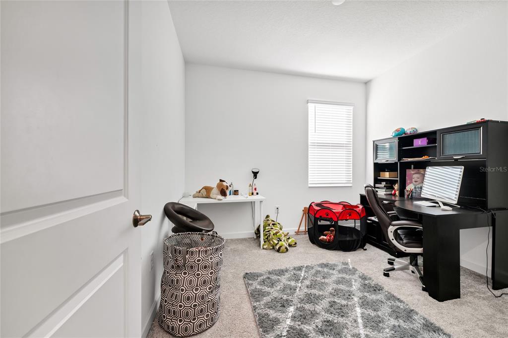 5656 Quiet Palm Loop St. Cloud, FL 34771 - Photo 18 of 36 a bedroom with a bed and a window