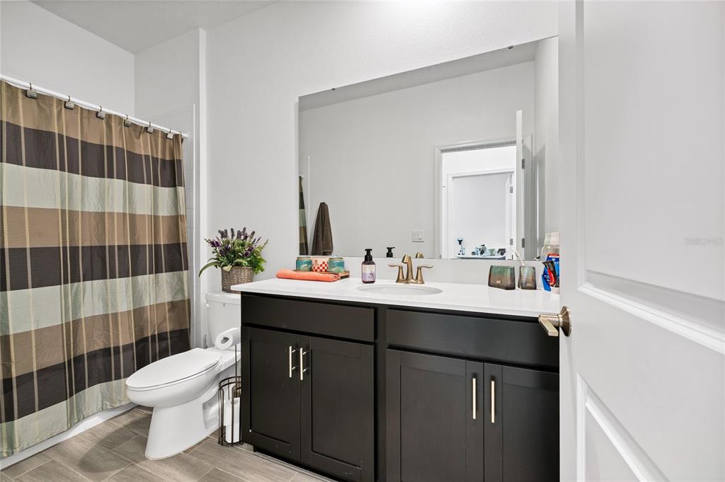 5656 Quiet Palm Loop St. Cloud, FL 34771 - Photo 20 of 36 a bathroom with a sink toilet and shower