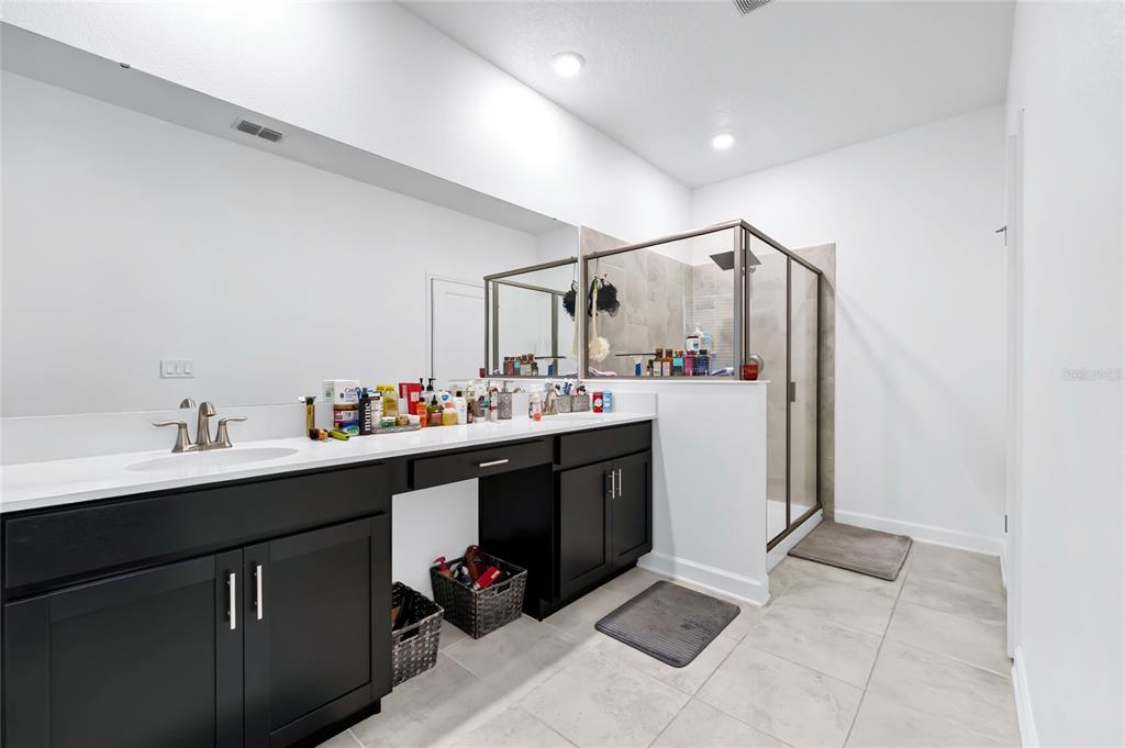 5656 Quiet Palm Loop St. Cloud, FL 34771 - Photo 25 of 36 a bathroom with a sink vanity and mirror