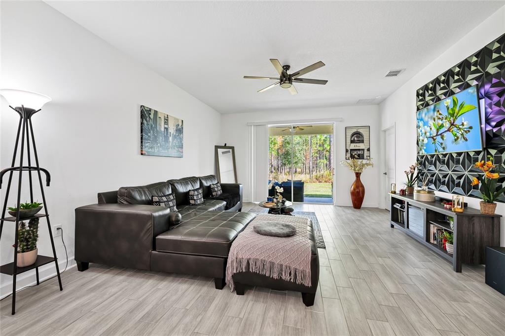 5656 Quiet Palm Loop St. Cloud, FL 34771 - Photo 8 of 36 a living room with furniture and a flat screen tv