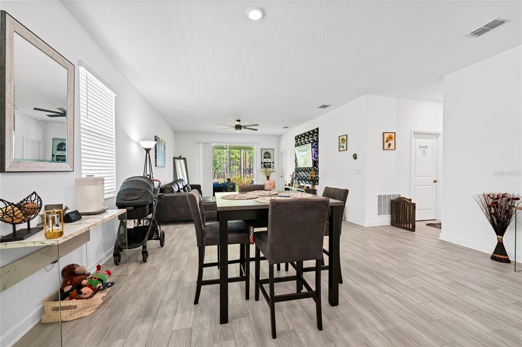 5656 Quiet Palm Loop St. Cloud, FL 34771 - Photo 10 of 36 a view of a dining room with furniture and wooden floor