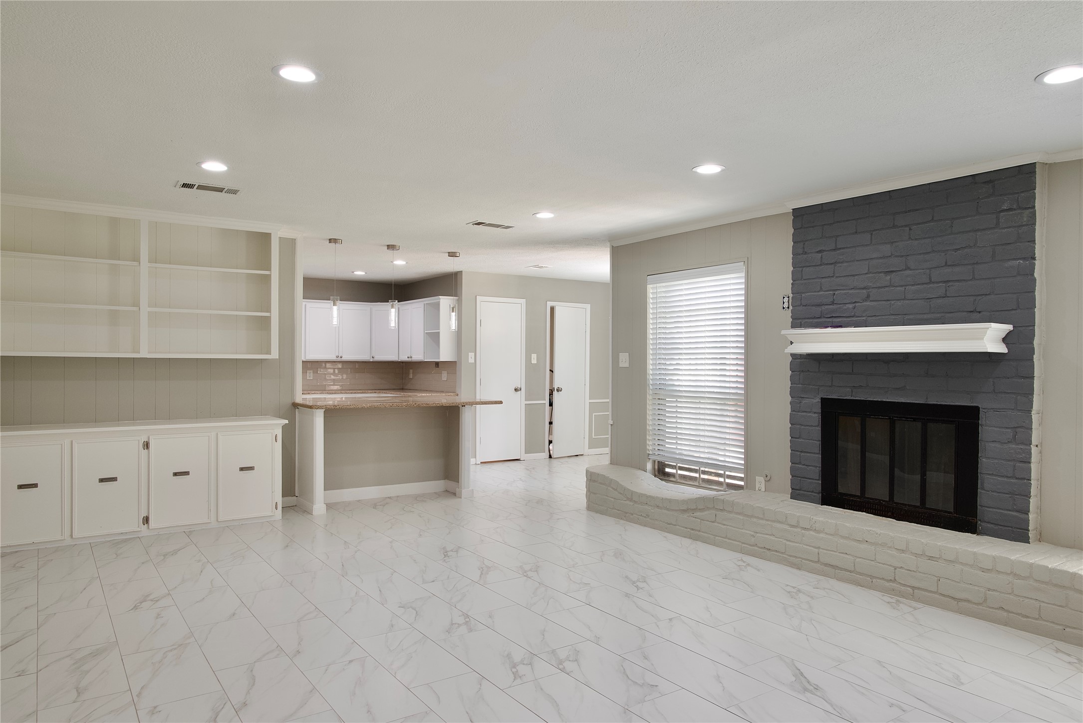 723 Leaflet Lane Spring, TX 77388 - Photo 24 of 41 a open kitchen with white cabinets and a fireplace