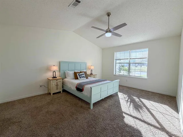 a white bed sitting in a bedroom next to a window
