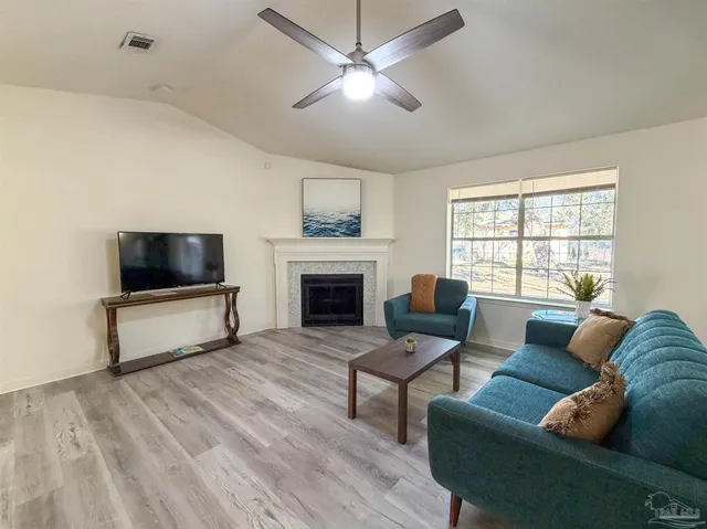 a living room with furniture a flat screen tv and a fireplace