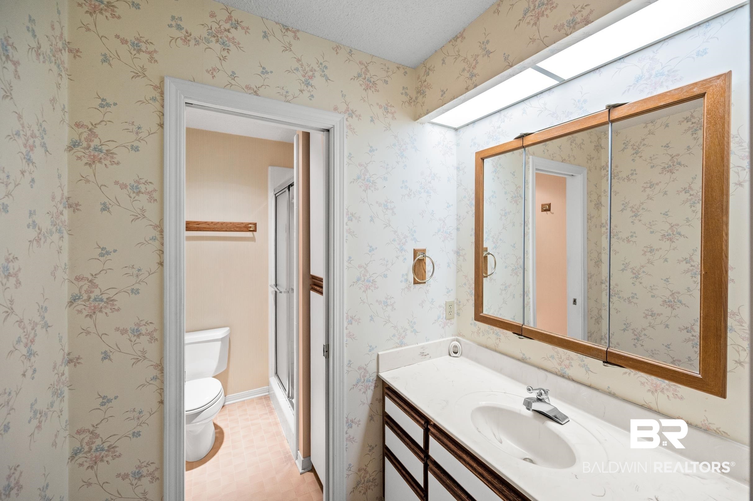 303 West Palm Avenue Foley, AL 36535 - Photo 22 of 32 Bathroom featuring vanity, toilet, a textured ceiling, and tile patterned flooring