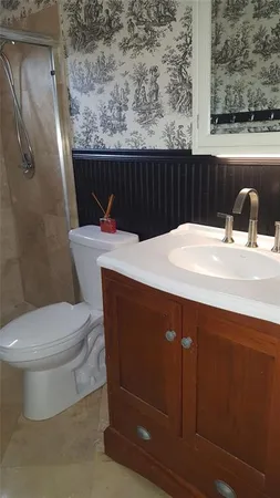 a bathroom with a sink a toilet and a shower