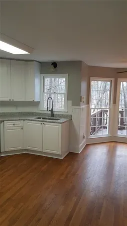 a kitchen with stainless steel appliances granite countertop a sink and wooden floor