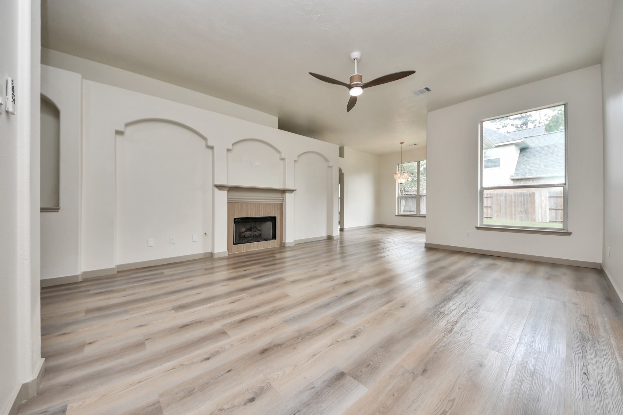 14423 Gadwall Court Houston, TX 77044 - Photo 17 of 42 an empty room with wooden floor fireplace and windows