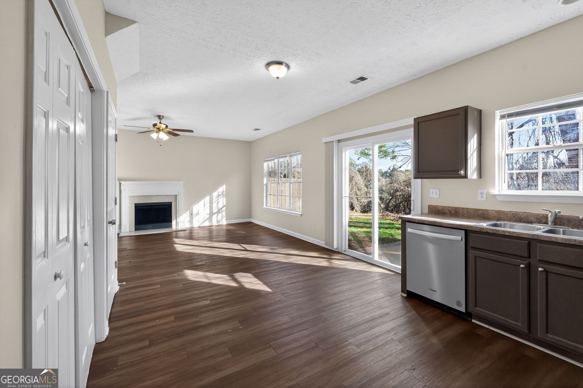 4292 Linecrest Lane Ellenwood, GA 30294 - Photo 15 of 33 a open kitchen with granite countertop a stove top oven a sink dishwasher and a fireplace with wooden floor