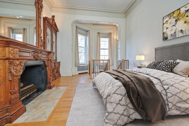 a view of a livingroom with wooden floor and a fireplace