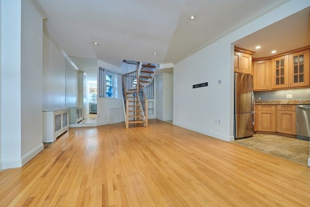 a view of empty room with wooden floor