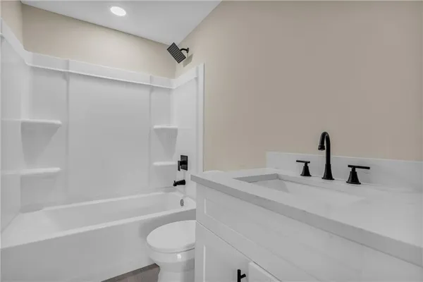 a bathroom with a tub sink toilet and a mirror