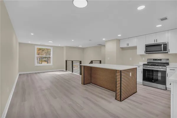 a kitchen with stainless steel appliances a stove top oven and a sink