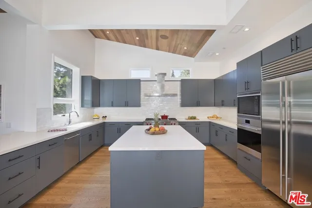 a kitchen with a sink a stove a dining table and chairs