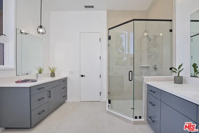 a spacious bathroom with a shower sink and mirror