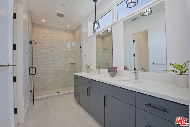 a bathroom with a double vanity sink and a mirror