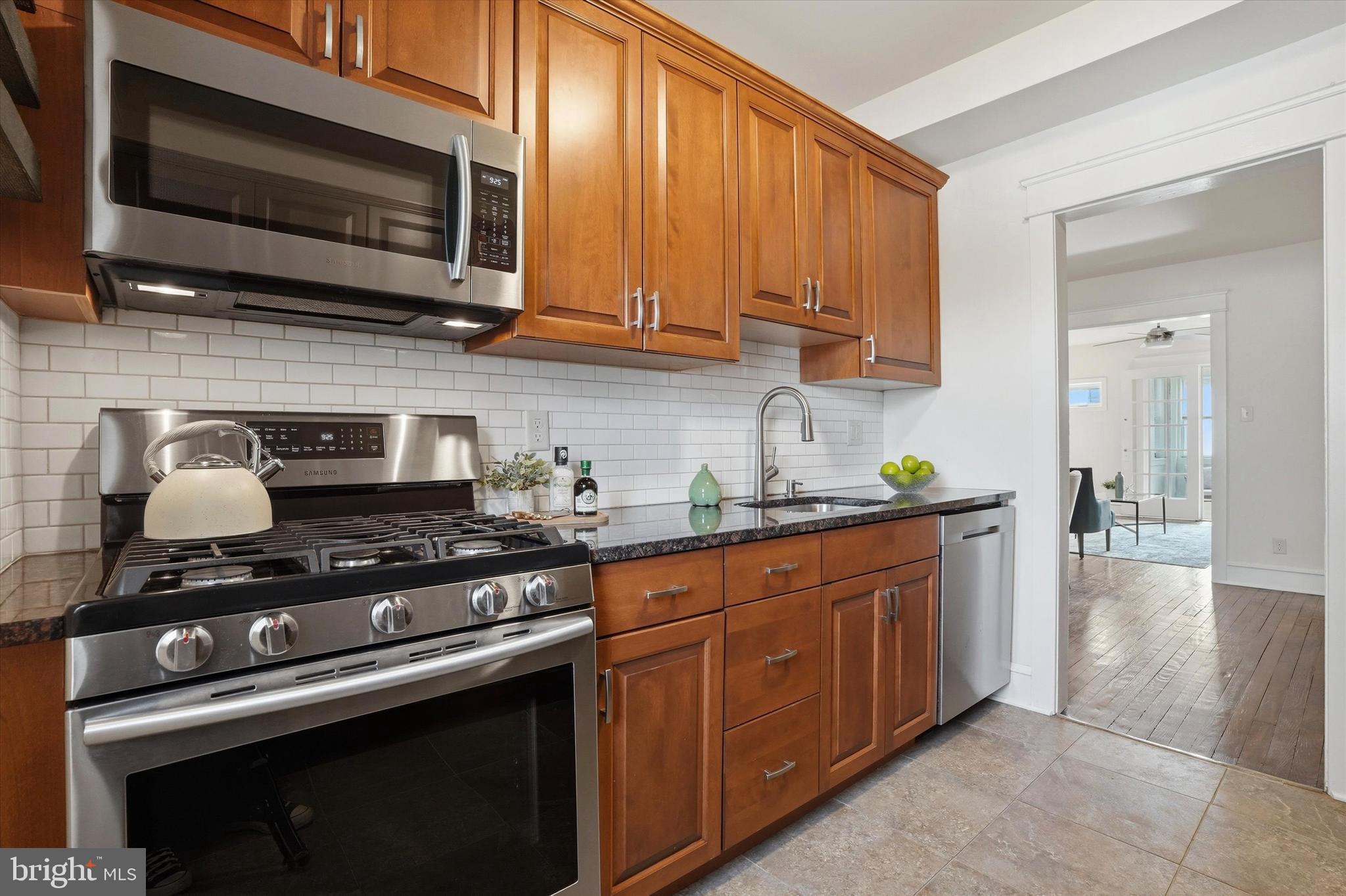 18 Vernon Road Havertown, PA 19083 - Photo 11 of 25 a kitchen with stainless steel appliances a stove a microwave cabinets and a refrigerator
