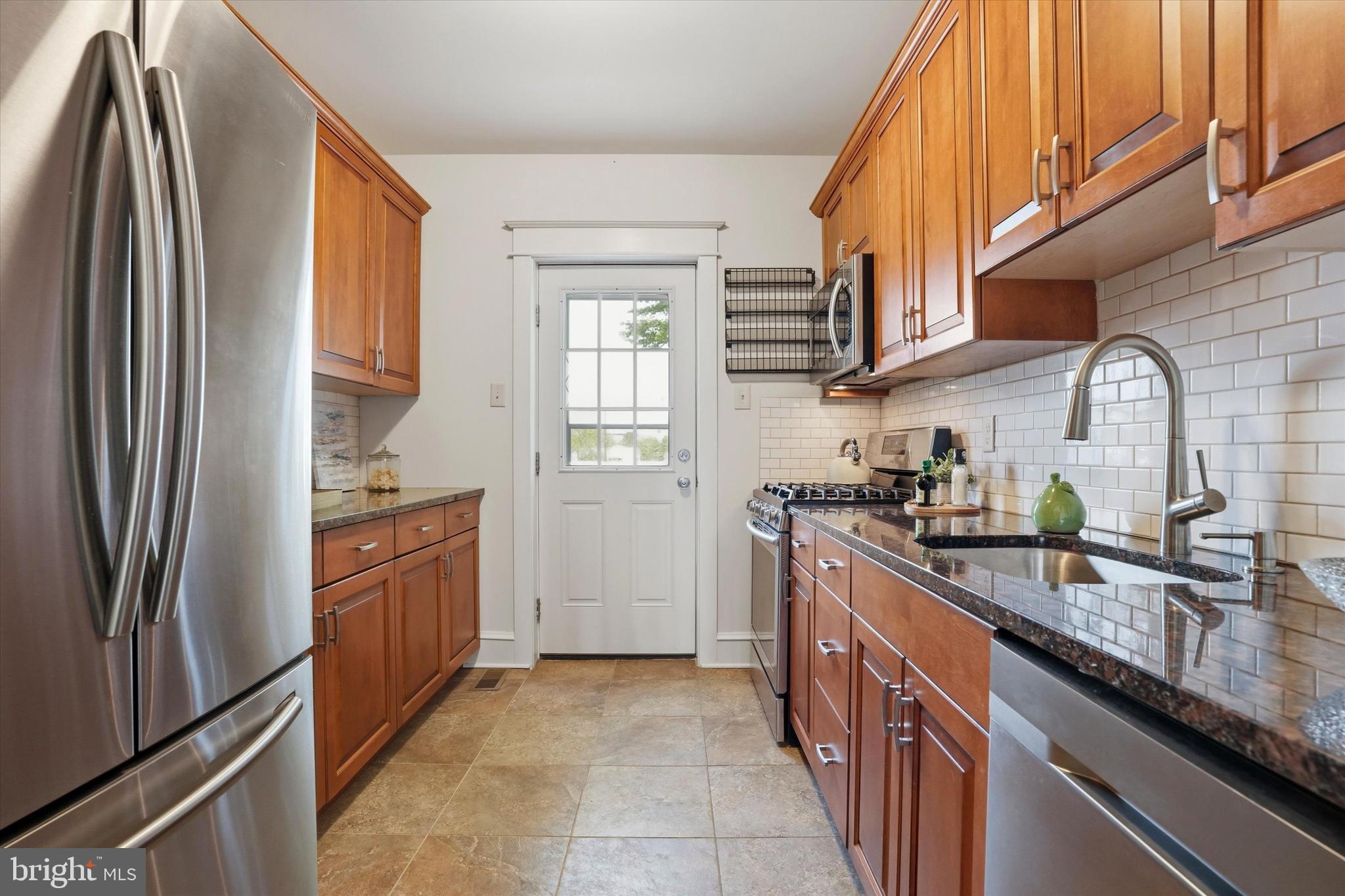 18 Vernon Road Havertown, PA 19083 - Photo 9 of 25 a kitchen with stainless steel appliances granite countertop a refrigerator a sink a stove and island