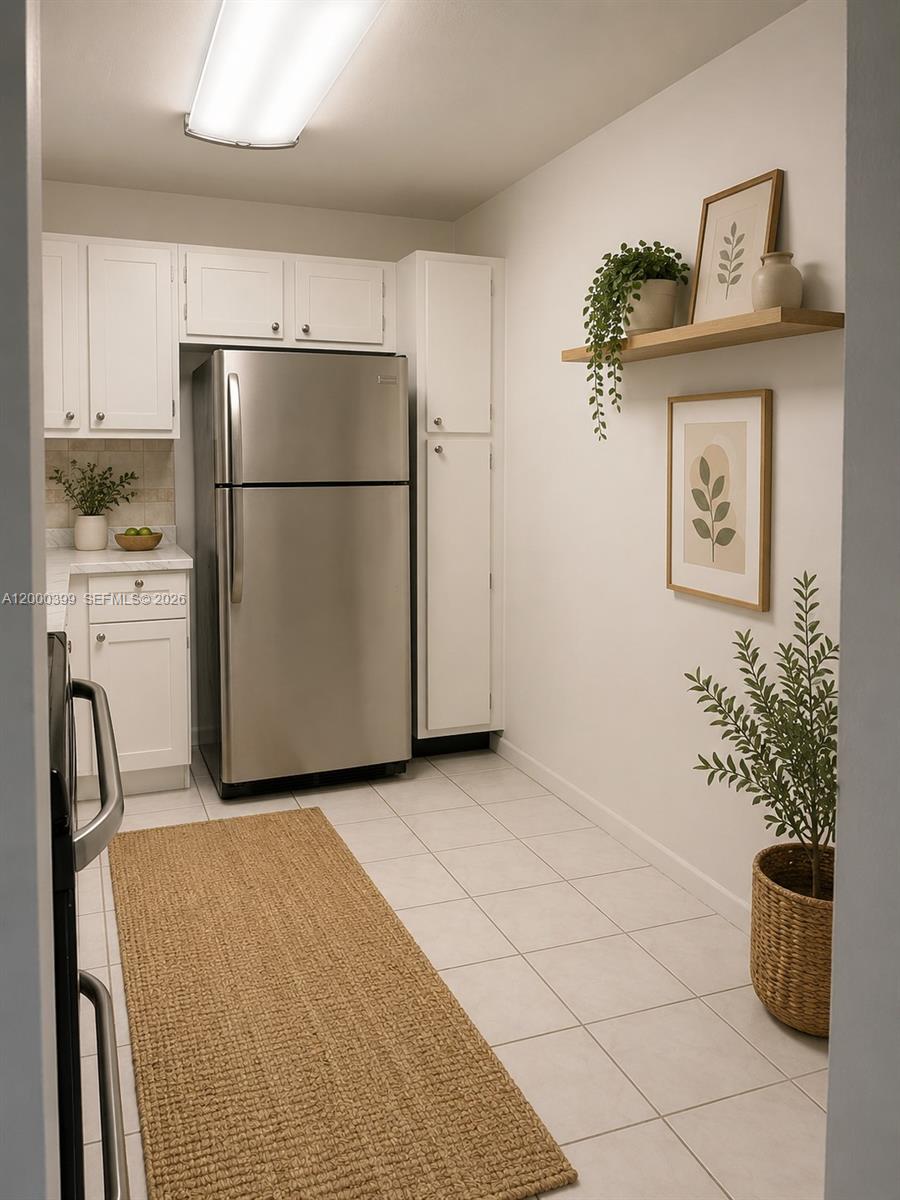 8050 West McNab Road, Unit 206 Tamarac, FL 33321 - Photo 35 of 37 a kitchen with a refrigerator and cabinets