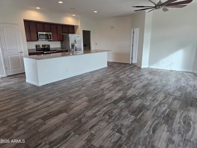 a view of kitchen with kitchen island stainless steel appliances refrigerator sink and microwave