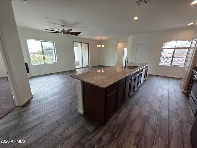 an open kitchen with sink and wooden floor